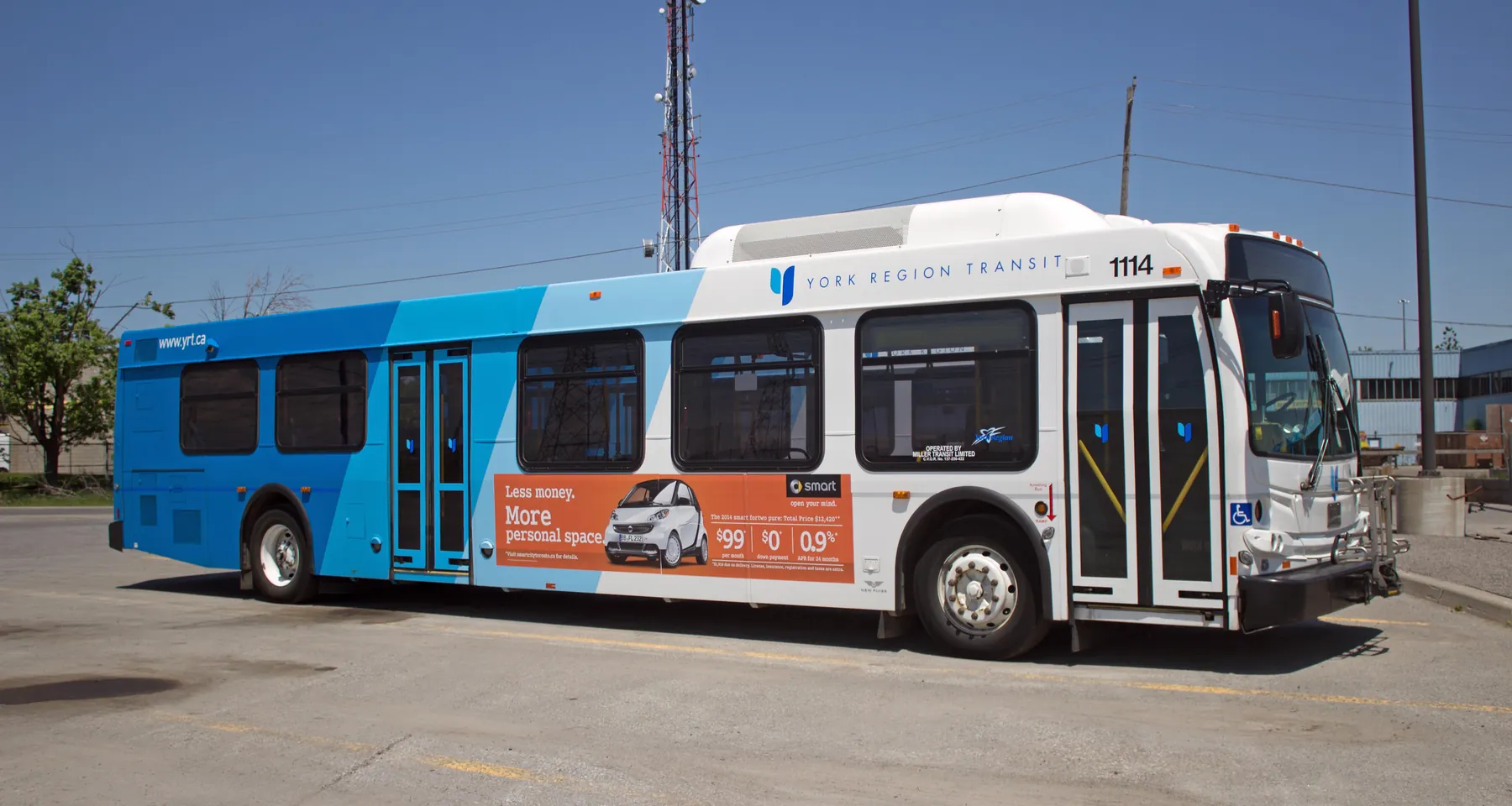 A blue and white York Region Transit bus parked in the Miller Transit yard.