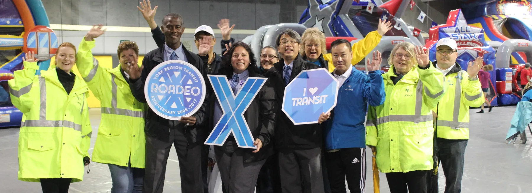 Miller Transit staff in high-visibility jackets cheering with Roadeo signs.
